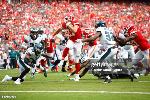 Tight end Travis Kelce of the Kansas City Chiefs leaps over defenders into the end zone for a touchdown during the 2nd half of the game against the...