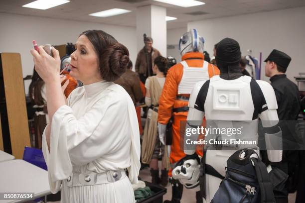 View of cast members, in various costumes from the 'Star Wars' films, as they finalize preparations backstage at the Cradle of Aviation Museum,...