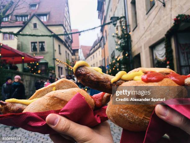 eating bratwurst at christmas market, bavaria, germany - dorffest stock-fotos und bilder