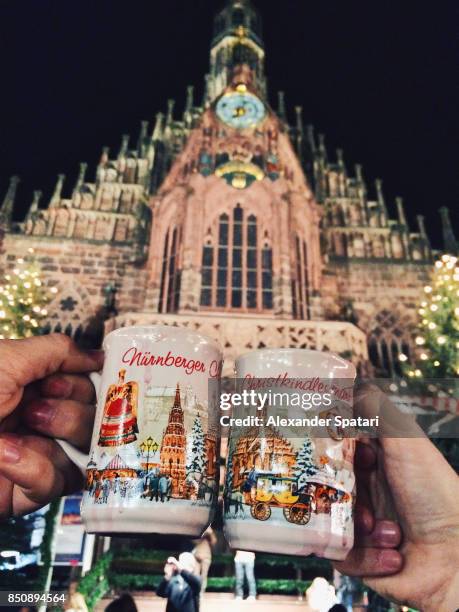 drinking gluhwein (mulled wine) at christmas market in germany - nuremberg stock pictures, royalty-free photos & images