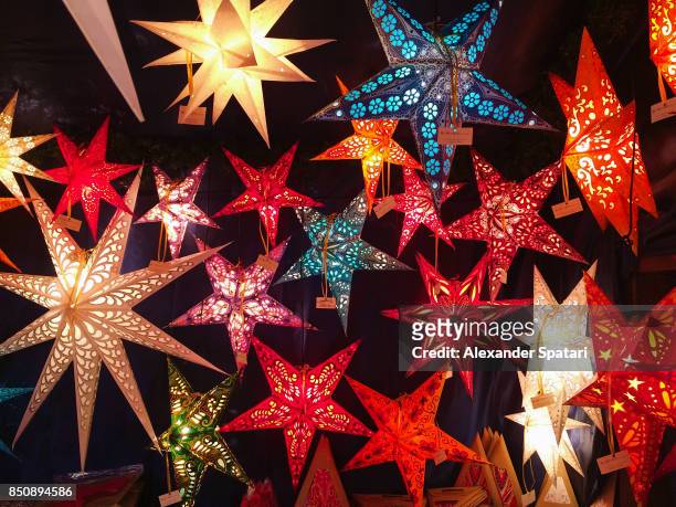 starshaped lanterns on christmas market in nurnberg, bavaria, germany - holiday lights stock-fotos und bilder