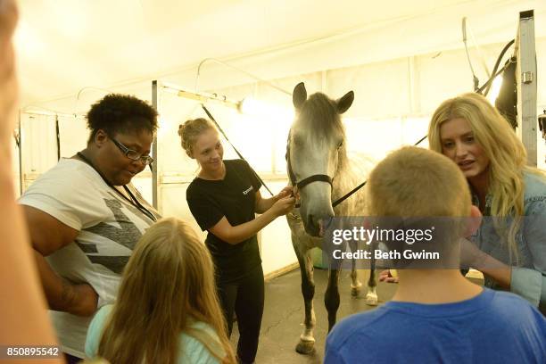 Taurus Bush with the kids feeding the horses at Odysseo on September 21, 2017 in Nashville, Tennessee.