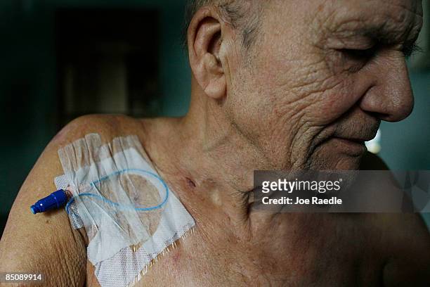 Robert Granville sits, with a intravenous tube in his shoulder for medicine to help fight an infection, in his wheel chair on February 25, 2009 in...