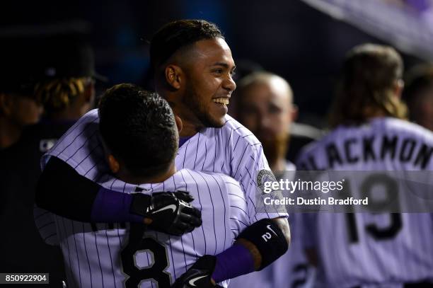Alexi Amarista of the Colorado Rockies celebrates a run scored with Gerardo Parra during a game against the San Diego Padres at Coors Field on...