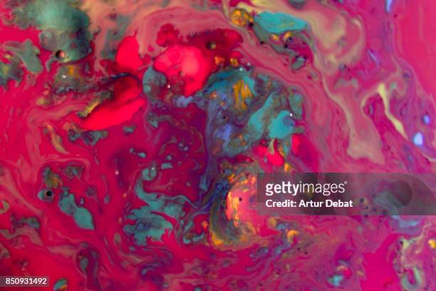 stunning abstract view of colorful paint flowing like lava creating new and surreal landscape taken from another planet. - liquid galaxy stock pictures, royalty-free photos & images