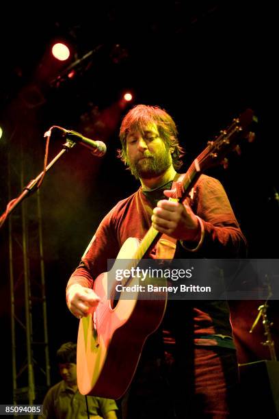 Photo of KING CREOSOTE, Kenny Anderson performing on stage, playing acoustic guitar