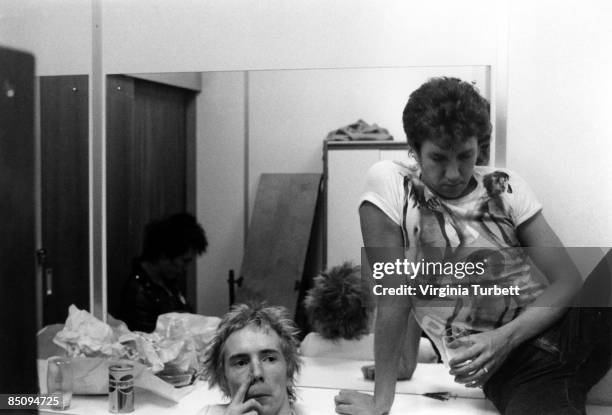 Photo of Steve JONES and Johnny ROTTEN and SEX PISTOLS; Johnny Rotten and Steve Jones having a drink in the dressing room on set of the Pretty Vacant...