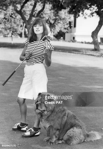Nicole Calfan avec son chien sur un terrain de golf en juillet 1976, France.