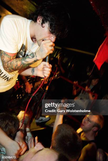Photo of THIS IS HELL and Travis REILLY, Travis Reilly performing on stage at Sweeney Todd's rock bar, audience