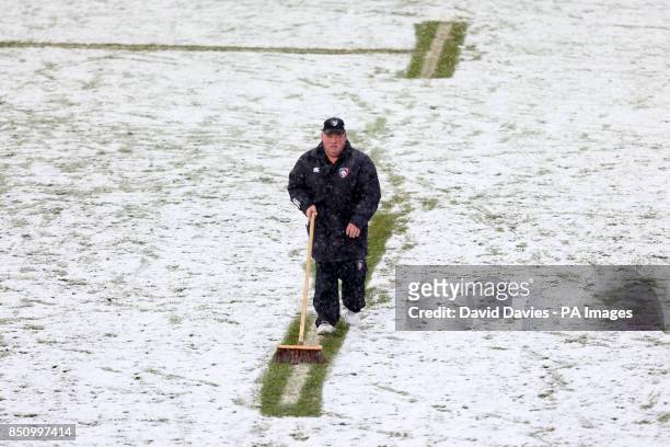 Groundstaff brush snow off the pitch during the Heineken Cup Pool 2 match at Welford Road, Leicester.