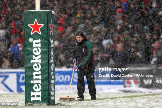 Groundstaff brush snow off the pitch during the Heineken Cup Pool 2 match at Welford Road, Leicester.