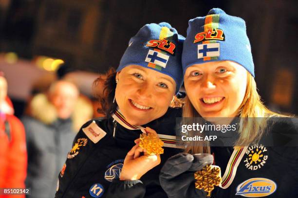 Aino Kaisa Saarinen of Finland celebrates with her teammate Virpi Kuitunen during the medal ceremony after their victory in the women's team sprint...