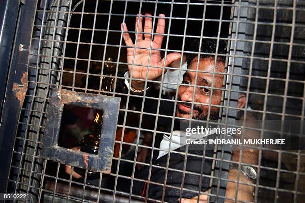 "Slumdog Millionaire" Indian sound engineer, Resul Pookutty displays his Oscar statue from inside a police vehicle after arriving back from the...