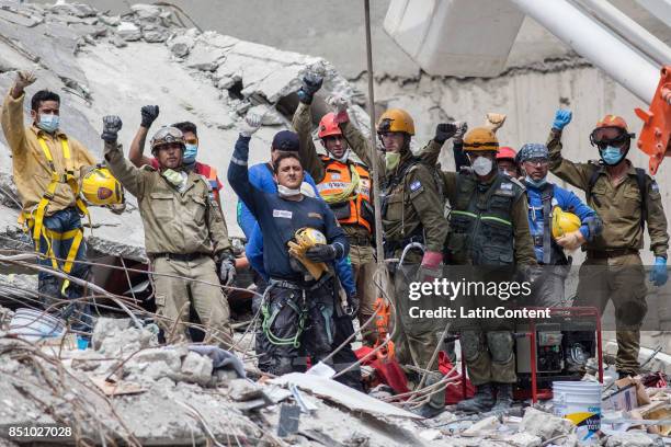 Israeli and Mexican rescuers work at the top of a destroyed building trying to recover the body of a man two days after the magnitude 7.1 earthquake...