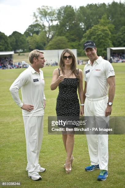 Elizabeth Hurley goes to flip the coin for the toss with team captains England's Michael Vaughan and partner, Australia's Shane Warne, before play at...