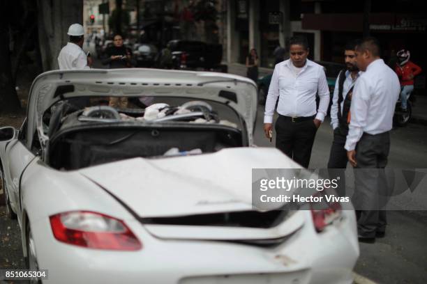 Destroyed Porsche car is seen by a group of men two days after the magnitude 7.1 earthquake jolted central Mexico killing more than 250 hundred...