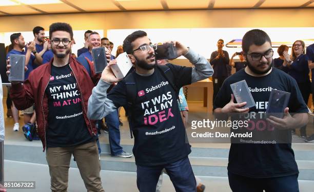 Abdal Salem,Mazzen Kaourouche and Rami Dan Daci, who had been queueing for eleven days, display their purchases at the Apple Store on September 22,...