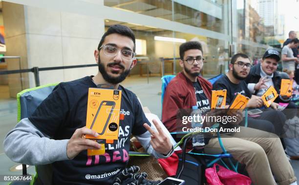 Abdal Salem,Mazzen Kaourouche and Rami Dan Daci, who had been queueing for eleven days, display free product given to them at the Apple Store on...