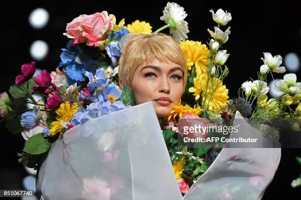 Model Gigi Hadid presents a creation for fashion house Moschino during the Women's Spring/Summer 2018 fashion shows in Milan, on September 21, 2017....