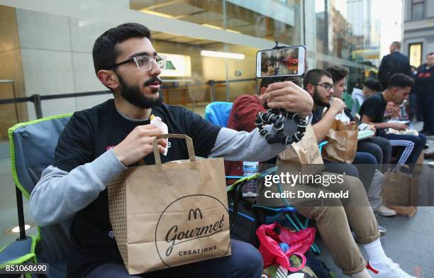 Mazzen Kaourouche, who had been queueing for eleven days with his two friends, films his every move before being allowed inside for the release of...