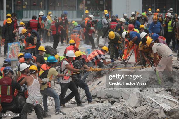 Rescuers and volunteers work in a textile factory that collapsed two days after the magnitude 7.1 earthquake jolted central Mexico killing more than...