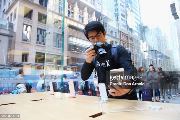 Man films product inside as people queue outside for the release of the iPhone 8 and 8 Plus at Apple Store on September 22, 2017 in Sydney,...