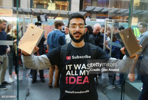 Mazzen Kaourouche, who had been queueing for eleven days with his two friends, displays his purchases at the Apple Store on September 22, 2017 in...