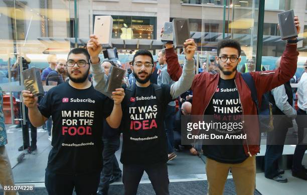 Rami Dan Daci,Mazzen Kaourouche and Abdal Salem, who had been queueing for eleven days, display their purchases at the Apple Store on September 22,...