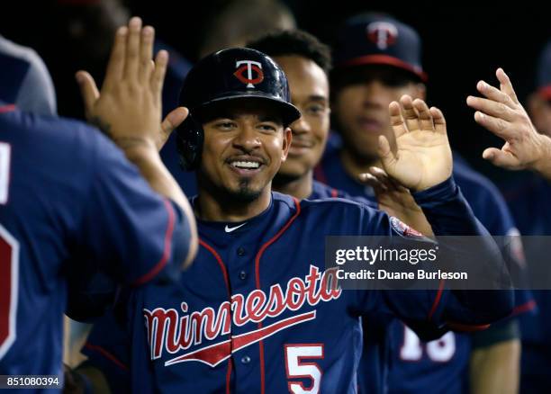 Eduardo Escobar of the Minnesota Twins celebrates in the dugout after scoring against the Detroit Tigers on a single by Byron Buxton during the...
