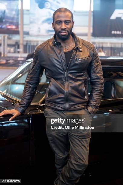 Mark Ebulue poses in front of a 1970 Dodge Charger R/T from the Fast and The Furious during the 'Fast & Furious Live' media launch day event at the...