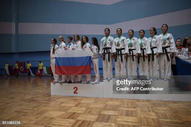 In a photo taken on September 21, 2017 team members from North Korea and Russia stand on the podium following the women's team event of the 20th ITF...