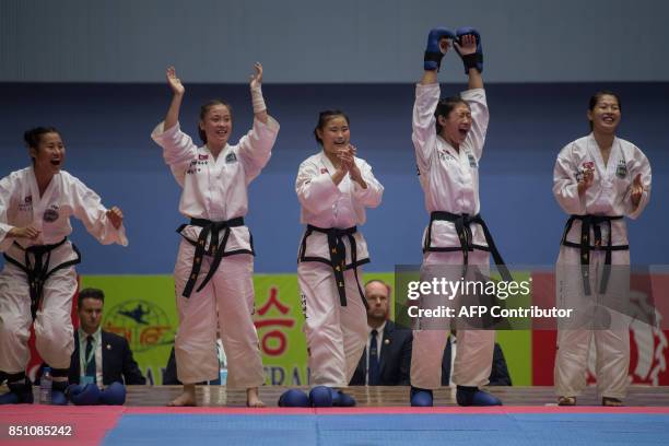 In a photo taken on September 21, 2017 team members from North Korea react following their win against Russia during the women's team event of the...