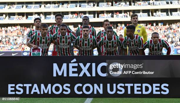 Brazil's Fluminense players pose behind a banner reading "Mexico we are with you" before their 2017 Sudamericana Cup football match against Ecuador's...