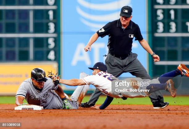 Jose Abreu of the Chicago White Sox avoids the tag of Jose Altuve of the Houston Astros in the third inning as second base umpire Mike Everitt looks...