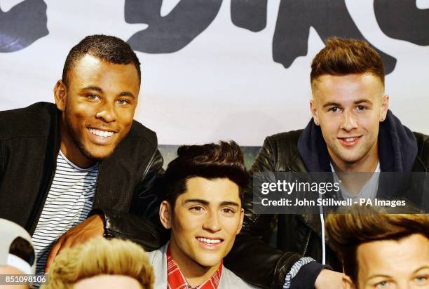 Ashford Campbell and Andy Merry members of the X-Factor TV show contestants The Risk boy-band, pose with former contestant the wax model of Zayn...