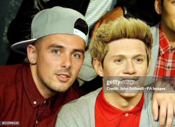 Charlie Healy a member of the X-Factor TV show contestants The Risk boy-band, poses with former contestant the wax model of Niall from One Direction...