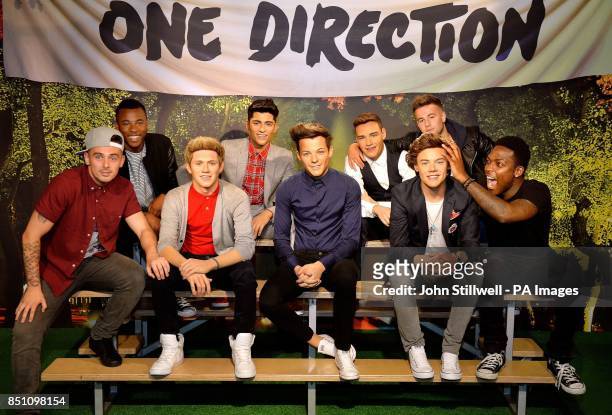Charlie Healy, Ashford Campbell, Andy Merry, and Derry Mensah members of the X-Factor TV show contestants The Risk boy-band, pose with wax models of...