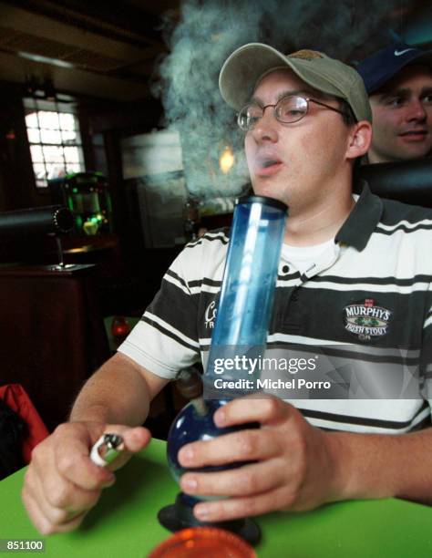 American tourist John Evan from San Francisco, CA enjoys a water pipe to inhale marijuana June 28, 2000 at a coffeeshop in Amsterdam, the...