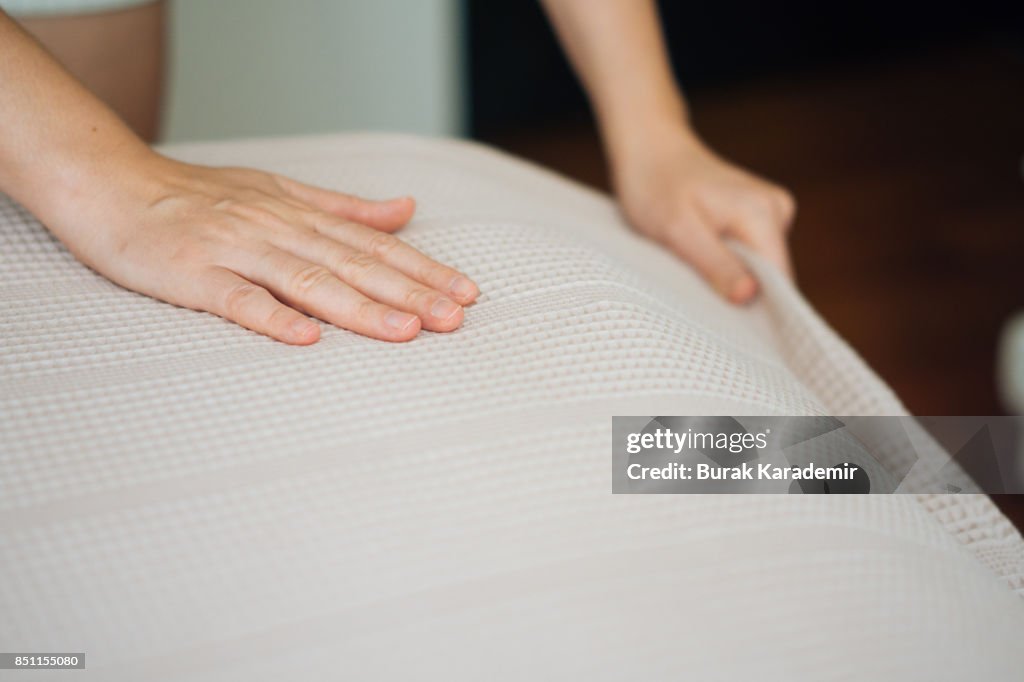 Woman Hands making a room bed