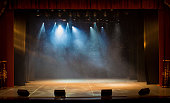 The stage of the theater illuminated by spotlights and smoke from the auditorium
