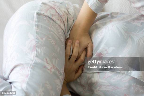 young adult woman holding her crotch - gastric ulcer stock-fotos und bilder
