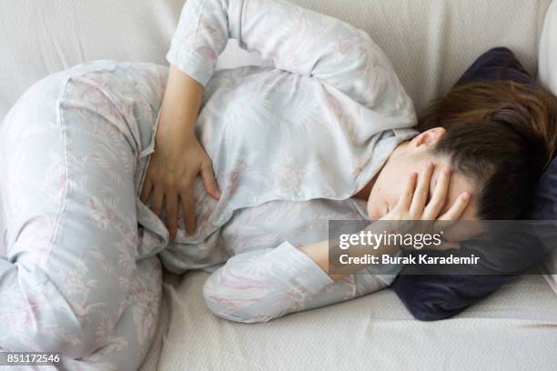 young adult woman holding her crotch - stomach ulcer fotografías e imágenes de stock