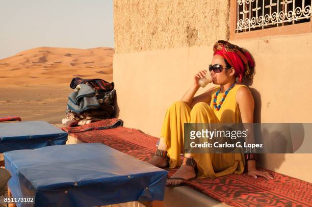 asian girl with turban and sunglasses sitting drinking water - hot arabic girl stock pictures, royalty-free photos & images