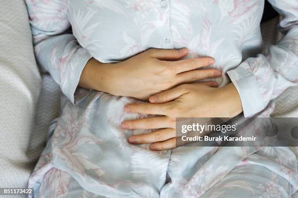 young adult woman holding her crotch - dolencia pélvica inflamatoria fotografías e imágenes de stock