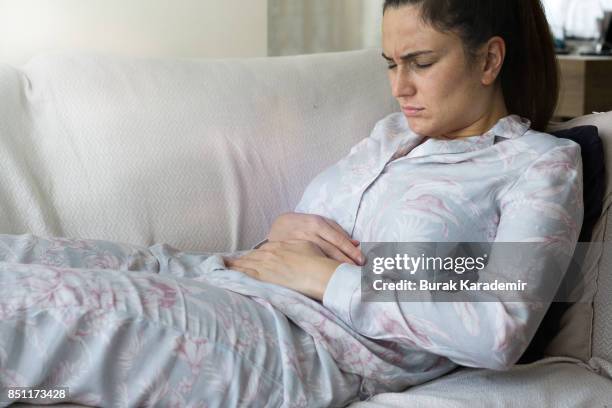 young adult woman holding her crotch - gastric ulcer stock-fotos und bilder