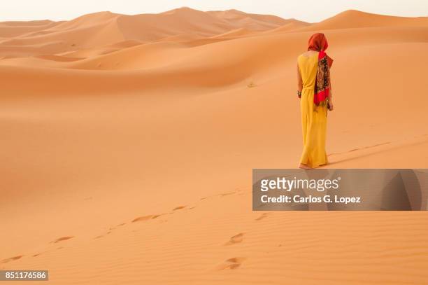 girl with head scarf walking on the sahara desert - hot arabic girl stock pictures, royalty-free photos & images