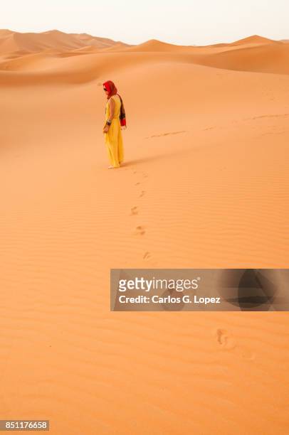 girl with head scarf walking on the sahara desert leaving footprints - hot arabic girl stock pictures, royalty-free photos & images