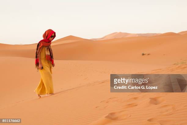 girl with head scarf walking towards sand dunes on the sahara - hot arabic girl stock pictures, royalty-free photos & images