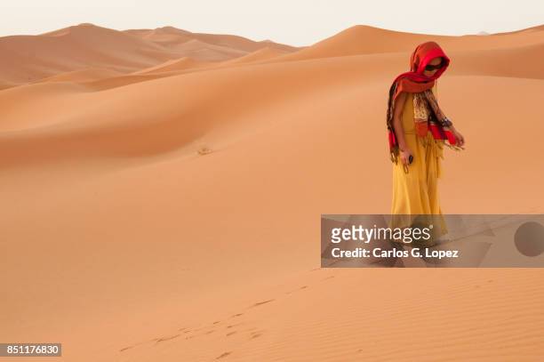 girl with head scarf walking on sand dunes on the sahara - hot arabic girl stock pictures, royalty-free photos & images