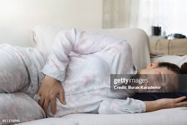 young adult woman holding her crotch - gastric ulcer fotografías e imágenes de stock